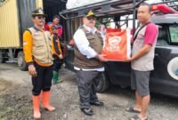 BANTUAN-Kepala Pelaksana BPBD Demak, Agus Sukiyo saat memberikan bantuan kepada salah satu korban terdampak banjir di Demak. (Foto Ist).