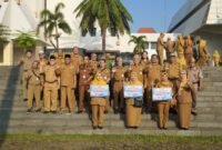 Jajaran aparatur sipil negara (ASN) bersama para penerima penghargaan berfoto bersama usai prosesi penyerahan dana sosial secara simbolis