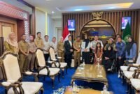Herman Deru (rompi krem, tengah kanan) berfoto bersama jajaran instansi pemerintah daerah dan perwakilan komunitas penyandang disabilitas usai menggelar audiensi di ruang pertemuan.