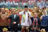 Tri Adhianto didampingi Menteri Kependudukan dan Pembangunan Keluarga RI, Dr. H. Wihaji serta Ketua TP PKK Kota Bekasi berfoto bersama ribuan peserta dalam acara puncak Kriyaan Lansia ke-2 Tahun 2026 di GOR Bang Yan, Stadion Patriot Candrabhaga, Bekasi