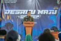 Kepala Dinas Tenaga Kerja Provinsi Lampung menyampaikan laporan kegiatan saat Pelatihan Vokasi Gerakan Cipta Ekonomi Produktif (GERCEP) 2026 di Balai Desa Trimulyo, Kecamatan Tegineneng