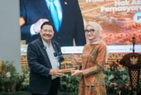 Wakil Gubernur Lampung menyerahkan cenderamata berupa miniatur Menara Siger kepada Wakil Menteri Koordinator Bidang Hukum, Hak Asasi Manusia, Imigrasi, dan Pemasyarakatan