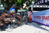 Petugas memeriksa kadar emisi gas buang sepeda motor milik warga di stan Uji Emisi Gratis Kota Yogyakarta.
