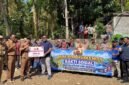 Tim Satgaswil DIY Densus 88 Antiteror Polri bersama aparat desa, TNI-Polri, dan warga membentangkan spanduk saat penyerahan bantuan sarana pompa air dan penyaluran air bersih di Kalurahan Kedungpoh