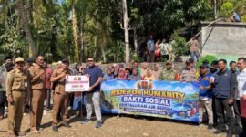 Tim Satgaswil DIY Densus 88 Antiteror Polri bersama aparat desa, TNI-Polri, dan warga membentangkan spanduk saat penyerahan bantuan sarana pompa air dan penyaluran air bersih di Kalurahan Kedungpoh