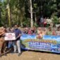 Tim Satgaswil DIY Densus 88 Antiteror Polri bersama aparat desa, TNI-Polri, dan warga membentangkan spanduk saat penyerahan bantuan sarana pompa air dan penyaluran air bersih di Kalurahan Kedungpoh