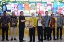 Penyerahan cinderamata di sela kegiatan Gerakan Ekonomi Kebersamaan Komunitas Megapro Affiliate PT GMA di Auditorium Poltekkes Bandar Lampung, Sabtu (26/9/2026).