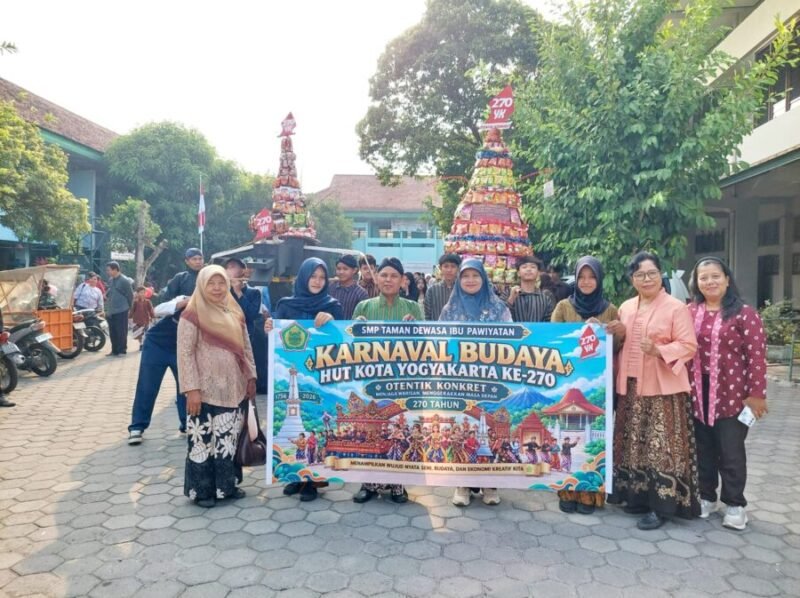 Kepala SMP Taman Dewasa Ibu Pawiyatan Ki Rosidi (keempat dari kiri), pengawas Disdikpora Kota Yogyakarta Retno Puryaningsih (kedua dari kanan), serta jajaran guru dan siswa membentangkan spanduk Karnaval Budaya di halaman sekolah, Yogyakarta