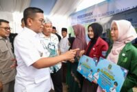 Andra Soni (kiri) berbincang dengan mahasiswi penerima manfaat usai menyerahkan secara simbolis Bantuan Keuangan kepada Pemerintah Desa melalui Program Sarjana Penggerak Desa di sela acara Peresmian Bangun Jalan Desa Sejahtera (Bang Andra) di Desa Sukaraja, Kecamatan Malingping,