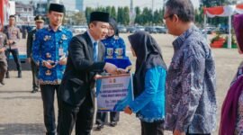 Marindo Kurniawan menyerahkan secara simbolis tali asih bagi anggota KORPRI purna bhakti saat Upacara Peringatan Hari Kesaktian Pancasila Tahun 2026 di Lapangan Korpri