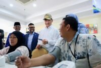 Suasana akrab saat peninjauan Program CKG. Ketua Komite III DPD RI Filep Wamafma (tengah bertopi) berbincang dengan tenaga kesehatan yang sedang melayani warga di RSUP Sitanala.