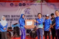 Marindo Kurniawan menyerahkan hadiah doorprize kepada peserta yang beruntung pada puncak Dies Natalis ke-47 Fakultas Teknik Unila.