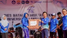 Marindo Kurniawan menyerahkan hadiah doorprize kepada peserta yang beruntung pada puncak Dies Natalis ke-47 Fakultas Teknik Unila.