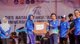 Marindo Kurniawan menyerahkan hadiah doorprize kepada peserta yang beruntung pada puncak Dies Natalis ke-47 Fakultas Teknik Unila.