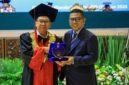 Andra Soni menerima plakat penghargaan dari pimpinan kampus dalam acara Wisuda XXVII STIE Bhakti Pembangunan di Auditorium Manggala Wanabakti