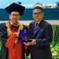 Andra Soni menerima plakat penghargaan dari pimpinan kampus dalam acara Wisuda XXVII STIE Bhakti Pembangunan di Auditorium Manggala Wanabakti